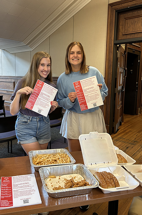 two LSU students hold flyers at event