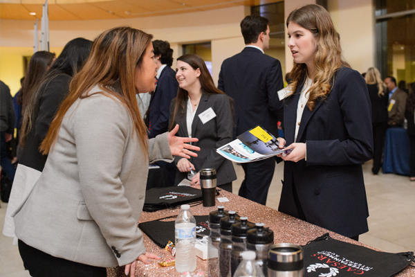 Company representative and student talk at a career fair. 