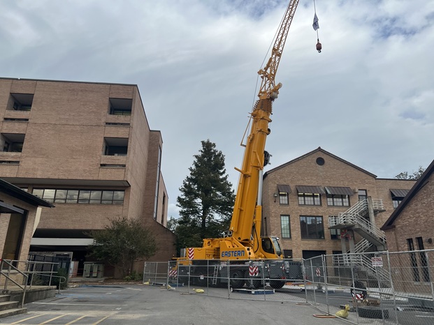 The photo is a picture of a crane behind a fence blocking public access.  The image depicts a safe work zone for operaters of the crane. 