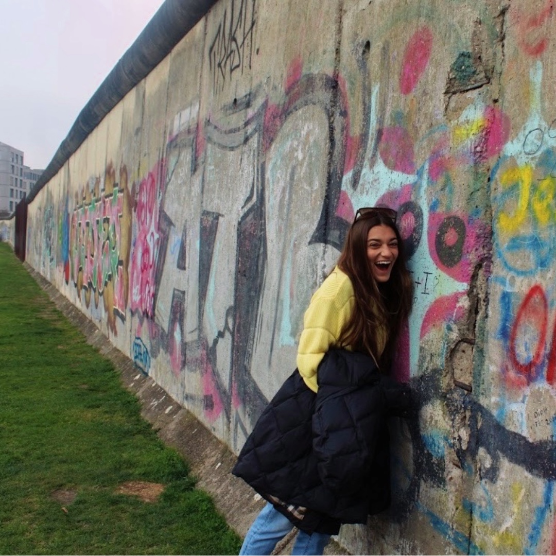A photo of an LSU Ogden Honors College student at a still-standing section of the Berlin Wall.